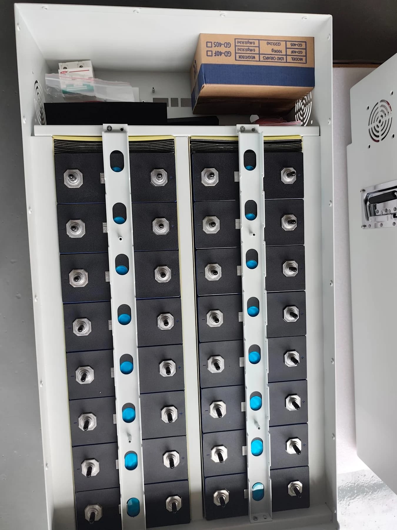 Open battery enclosure showing 16S cell layout